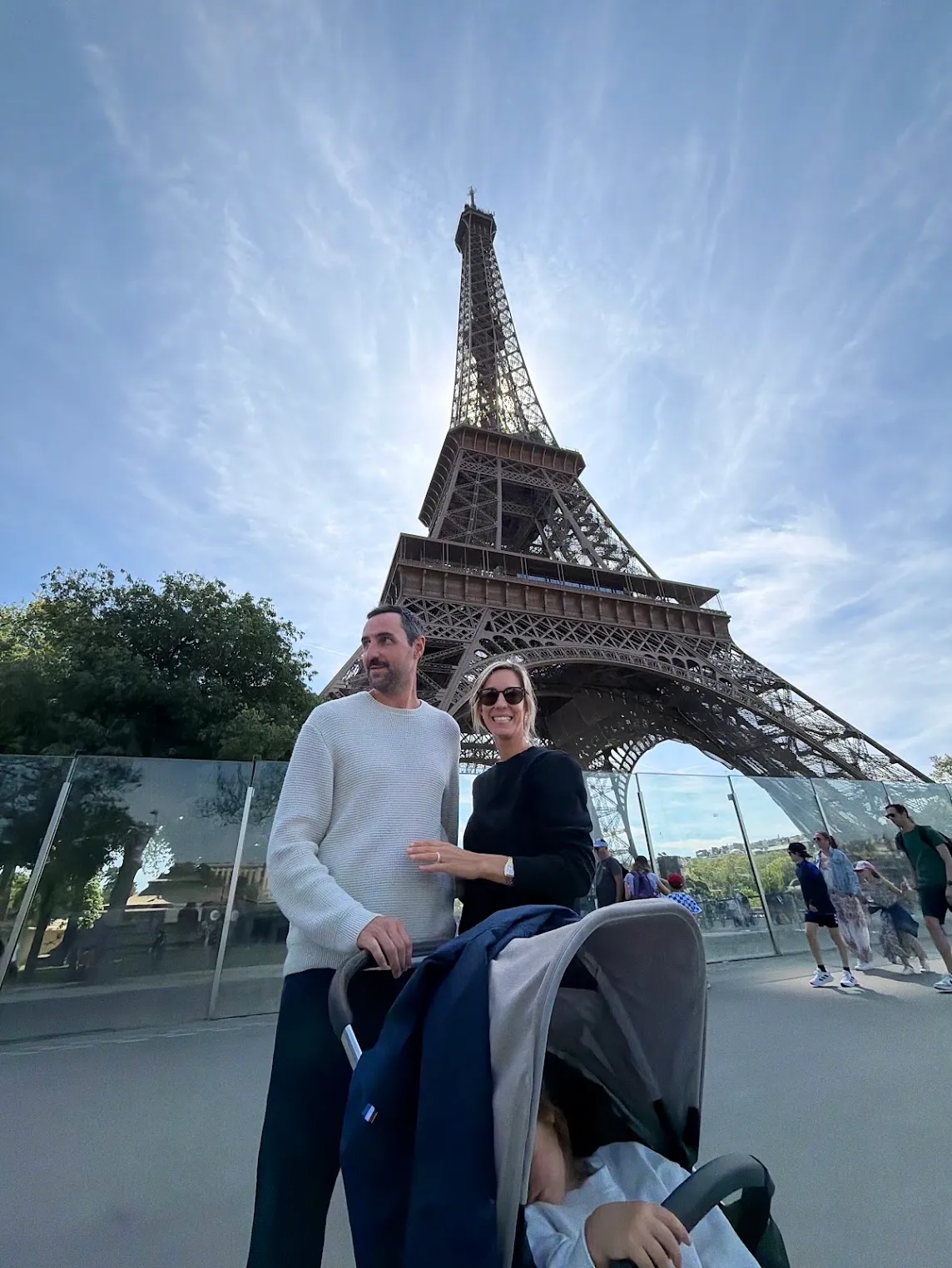 Mum and dad with a stroller in front of the Eiffel Tower in Paris.