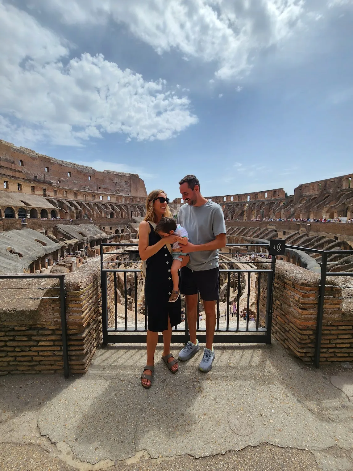 Corey and Jessica holding their baby inside the Colosseum in Rome.